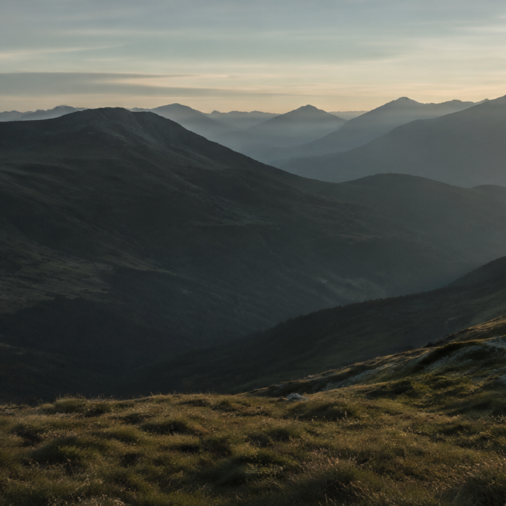 Quiet alpine valley and mountain ridges at sunrise